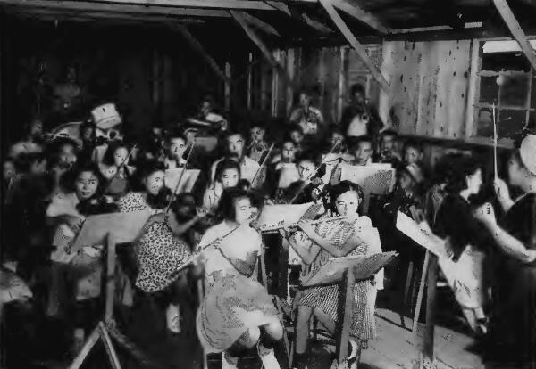 A teen-age orchestra tuning up under the leadership of a Japanese woman instructor at Salinas (California) Assembly Center