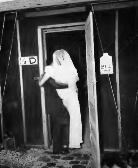 A groom carrying his bride across the threshold of their apartment at Stockton (California) Assembly Center